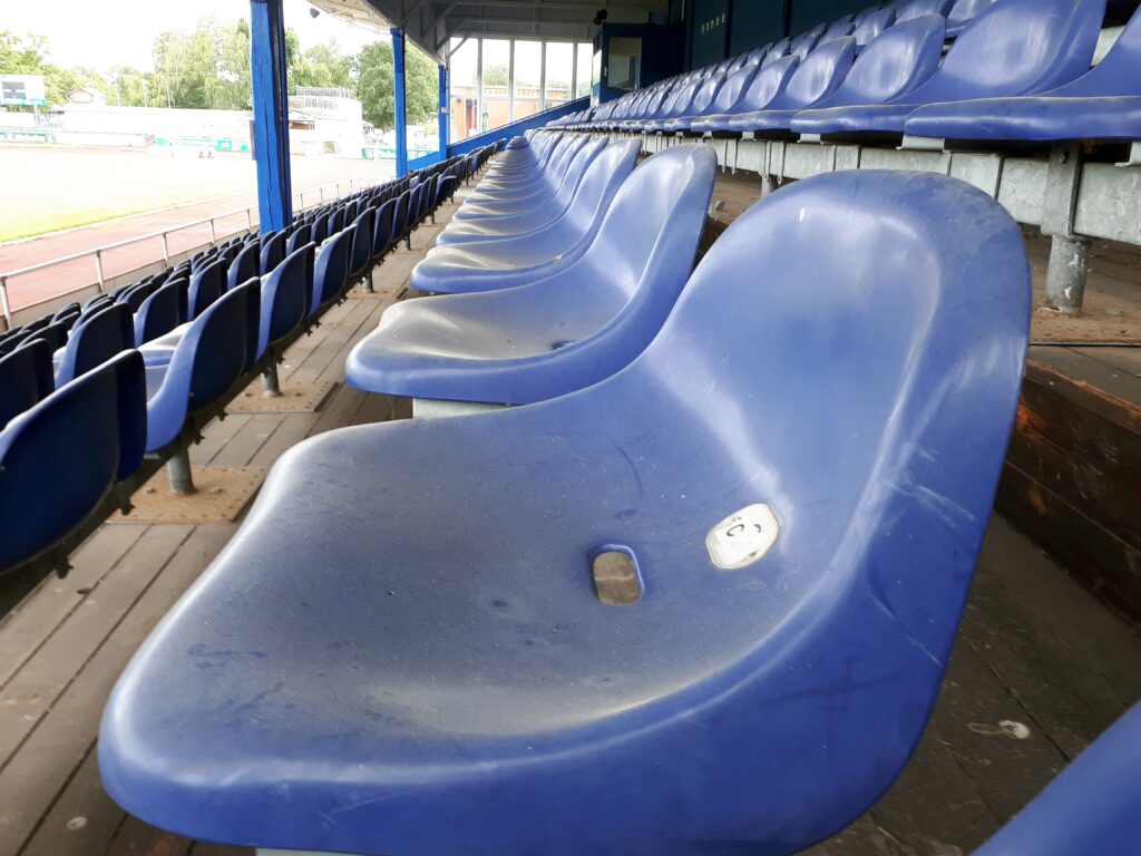 Blaue Sitzschalen auf der Holztribüne im Friedrich-Ebert-Stadion